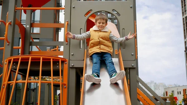 Kleine Jongen Lacht Terwijl Hij Van Glijbaan Glijdt Speelplaats Actief — Stockfoto
