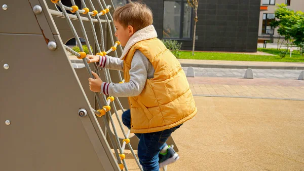 Kleiner Junge Klettert Auf Öffentlichem Spielplatz Auf Das Netz Aktives — Stockfoto