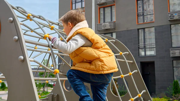 Mały Chłopiec Wspinający Się Siatkę Linową Publicznym Placu Zabaw Dla — Zdjęcie stockowe