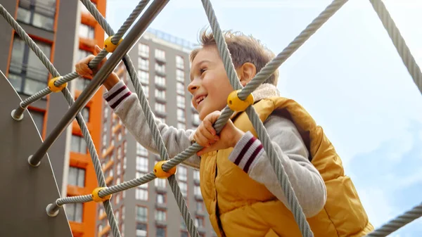 Bonito Menino Sorridente Escalando Rede Corda Parque Público Criança Ativa — Fotografia de Stock
