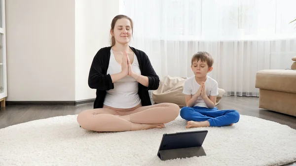 Mujer Sonriente Con Hijo Practicando Yoga Meditando Alfombra Casa Asistencia —  Fotos de Stock