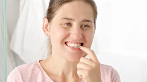 Portret Młodej Kobiety Pocierającej Zeskrobującej Płytkę Zębową Palcem Podczas Patrzenia — Zdjęcie stockowe