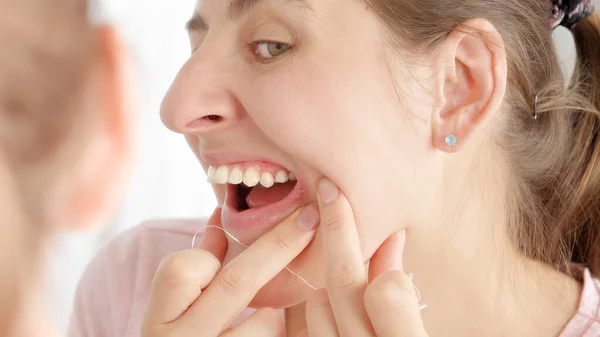 若いです女性の閉鎖見ますヘルペスオン彼女の唇に歯をきれいにしながら歯の花 — ストック写真