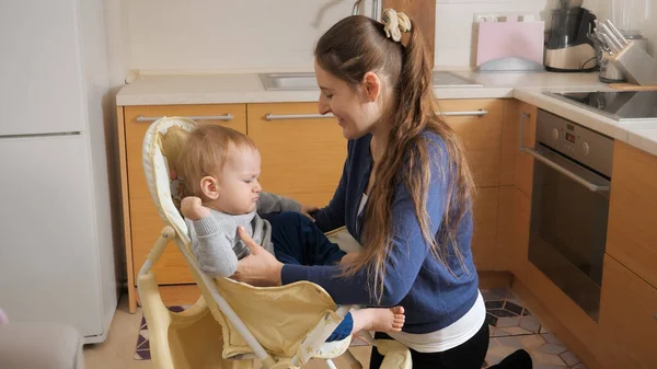 Joven Madre Cariñosa Sentando Hijo Bebé Silla Alta Para Alimentarlo — Foto de Stock