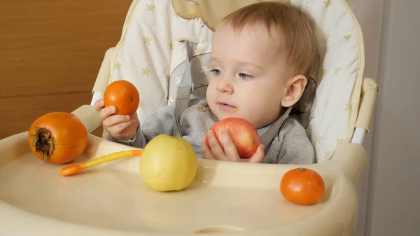 Retrato Bebé Lindo Sentado Trona Sosteniendo Frutas Frescas Sabrosas —  Fotos de Stock