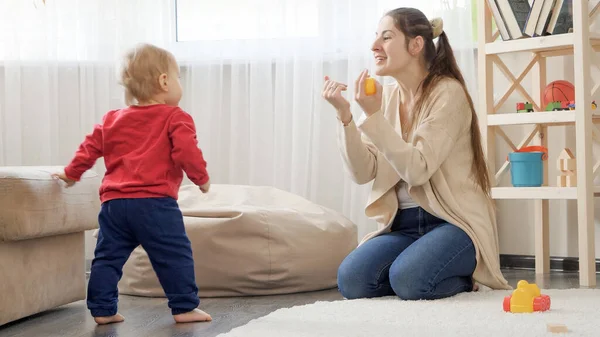 Happy Laughing Mother Cheering While Her Baby Son Making First — Stock Photo, Image