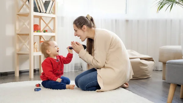 Onnellinen Hymyilevä Äiti Istuu Lattialla Leikkii Pienen Poikansa Kanssa Vauvan — kuvapankkivalokuva
