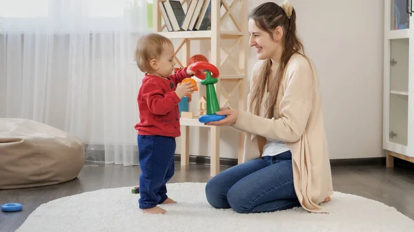 かわいい1歳の男の子が母親と遊んでおもちゃの塔を組み立てます 赤ちゃんの開発 子供の遊びゲーム 教育と学習 — ストック写真
