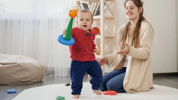 Kleiner Junge Jubelt Nachdem Eine Bunte Spielzeugpyramide Wohnzimmer Zusammengebaut Hat — Stockfoto
