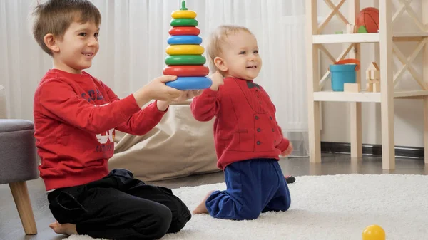 两个快乐的小男孩在客厅的地毯上组装玩具塔之后 笑着欢呼 儿童教育 婴儿发展 家庭游戏的概念 — 图库照片