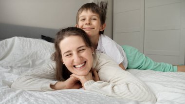 Sevgi dolu küçük bir çocuğun annesini öptüğü portresi. Mutlu aile kavramı, çocuklu ebeveynler, olumlu duygular ve evde rahatlama.