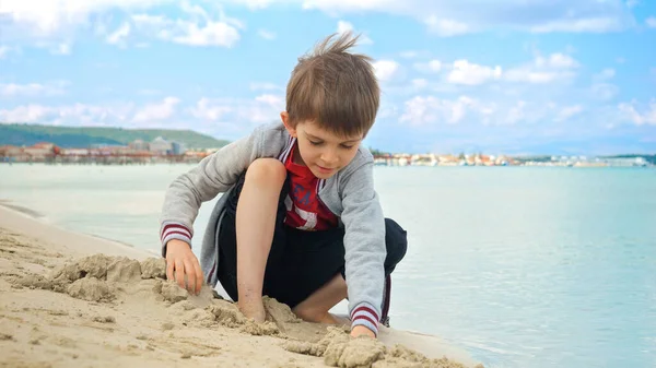 Chłopak Siedzi Plaży Kopie Bawi Się Piaskiem Pojęcie Turystyki Podróży — Zdjęcie stockowe