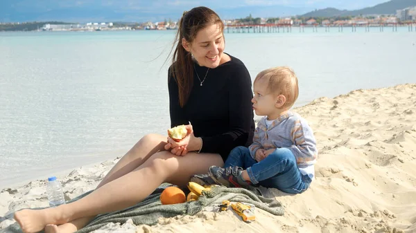 Młoda Kochająca Matka Urządzająca Piknik Piaszczystej Plaży Morskiej Swoim Synkiem — Zdjęcie stockowe