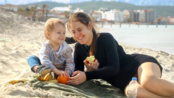 Mujer Alegre Con Hijo Pequeño Relajándose Playa Arena Haciendo Picnic —  Fotos de Stock