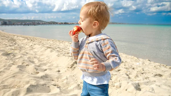 Mały Chłopczyk Świeże Jabłko Piaszczystej Plaży Morskiej Turkusową Wodą Oceanu — Zdjęcie stockowe