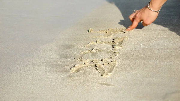 Fechar Mão Feminina Escrevendo 2023 Anos Areia Molhada Praia Mar — Fotografia de Stock