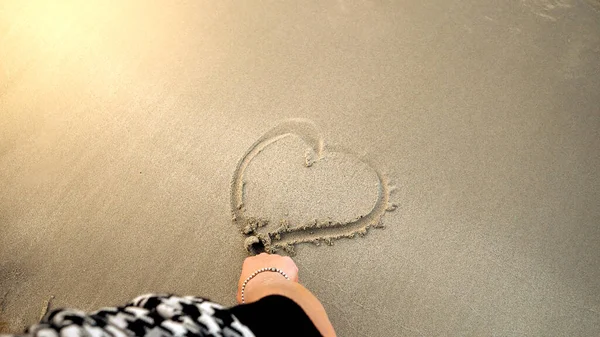 Fechar Mão Feminina Desenhando Uma Forma Coração Areia Molhada Praia — Fotografia de Stock