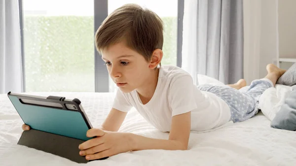 Młody Chłopiec Cieszy Się Czasem Ekranu Łóżku Korzystając Tabletu Odkrywania — Zdjęcie stockowe