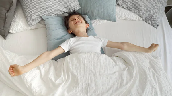 Küçük Bir Çocuğun Portresi Yatakta Uzanıyor Ellerini Uzatıyor Kameraya Gülümsüyor — Stok fotoğraf