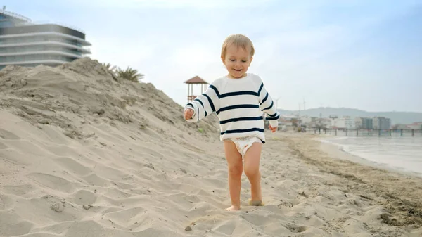 Cute Szczęśliwy Uśmiechnięty Chłopiec Maluch Spacerując Piaszczystej Plaży Morskiej Pojęcie — Zdjęcie stockowe
