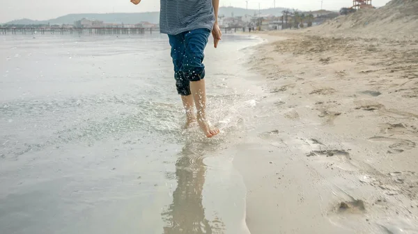 Radosny Chłopczyk Biegający Piaszczystej Plaży Rozpryskujący Wodę Szczęście Ekscytacja Podróżowaniem — Zdjęcie stockowe