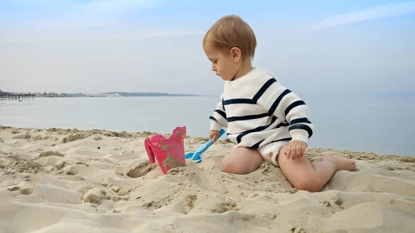 Maluch Szczęśliwie Bawi Się Plaży Kopie Piasek Łopatą Radość Ekscytacja — Zdjęcie stockowe