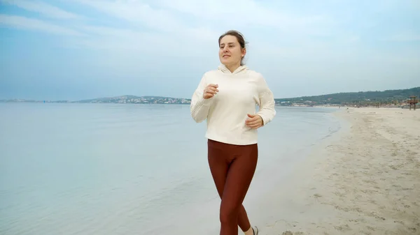 Fit Νεαρή Γυναίκα Απολαμβάνοντας Ένα Πρωινό Τρέξιμο Στην Αμμώδη Παραλία — Φωτογραφία Αρχείου
