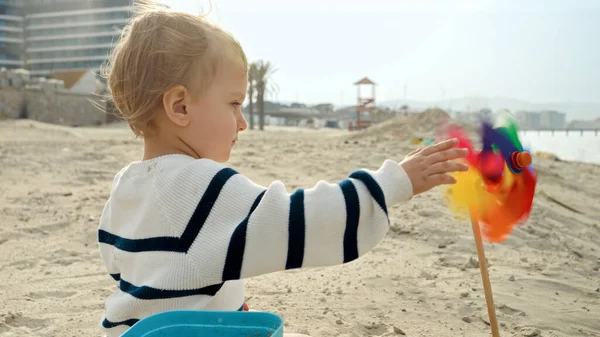 Kumlu Deniz Sahilinde Dönen Renkli Fırıldak Oyuncağıyla Oynayan Küçük Çocuğun — Stok fotoğraf
