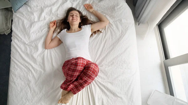 Женщина Пижаме Лежит Мягкой Кровати Большого Окна Счастливым Выражением Лица — стоковое фото