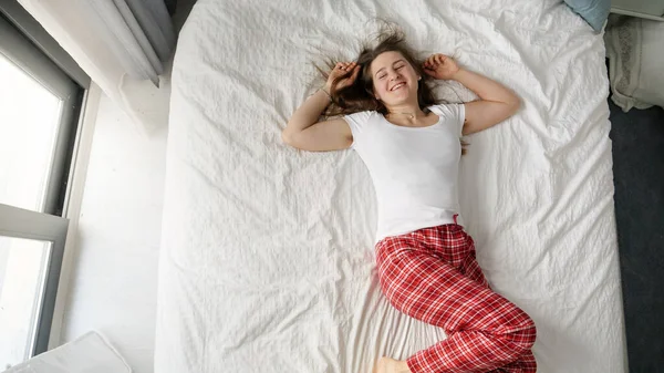 Улыбающаяся Молодая Женщина Уютной Пижаме Падает Мягкую Кровать Возле Большого — стоковое фото