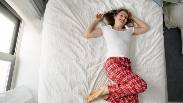 Mujer Joven Pijama Acostada Una Cama Con Una Gran Sonrisa — Foto de Stock
