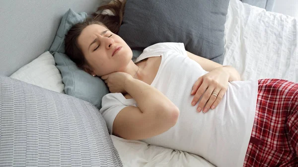 不快な枕の上で寝て首の痛みに苦しむパジャマ姿の若い女性の肖像画 医療問題 痛みの軽減と怪我の概念 — ストック写真