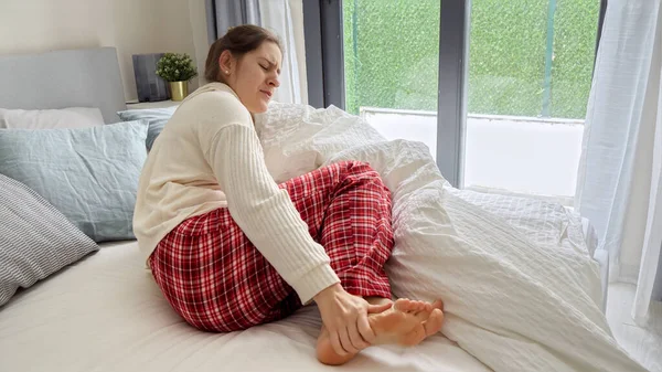 筋肉のけいれんで脚に強い痛みを感じた後 若い女性がベッドで目を覚ます 健康問題 痛みと外傷の概念 — ストック写真