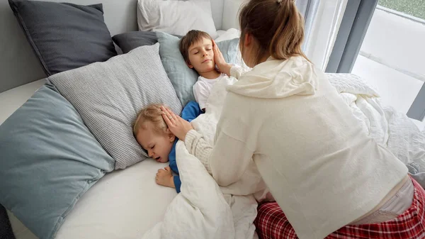 Два Мальчика Лежат Постели Пока Мать Покрывает Одеялом Концепция Семейного — стоковое фото