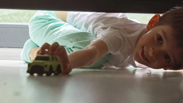 Liten Pojke Pyjamas Tittar Sängen Och Söker Efter Försvunna Leksaksbil — Stockfoto