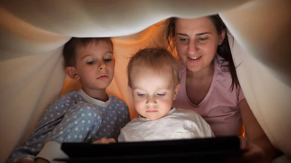 Милый Мальчик Матерью Братом Сидящий Одеялом Планшетным Компьютером Ночью Семья — стоковое фото