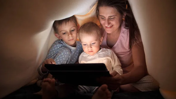 Szczęśliwa Rodzina Piżamie Przeglądająca Internet Oglądająca Filmy Tablecie Łóżku Pod — Zdjęcie stockowe