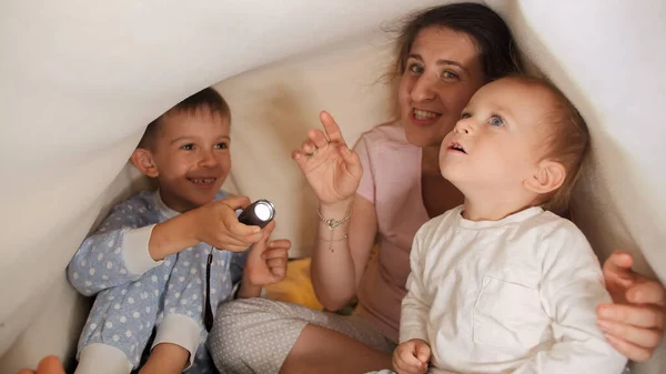 Madre Joven Sentada Debajo Una Manta Con Sus Dos Hijos —  Fotos de Stock