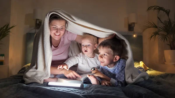 Familia Feliz Acostada Cama Por Noche Leyendo Libro Con Linterna — Foto de Stock