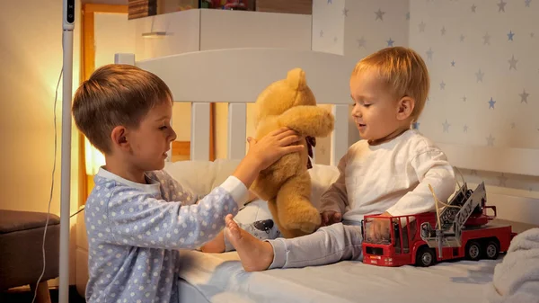 Dwóch Chłopców Piżamie Bawiących Się Zabawkami Łóżku Przed Snem Rodzina — Zdjęcie stockowe