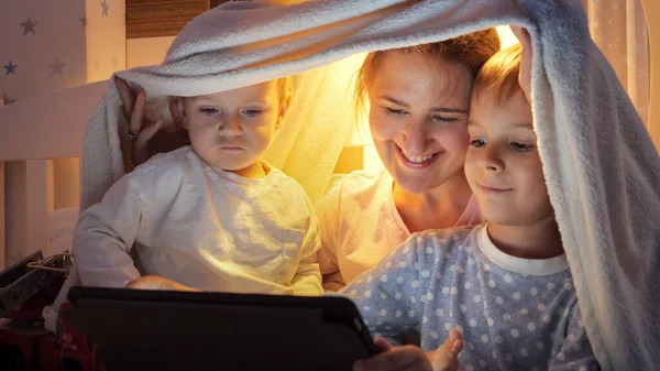 Två Leende Pojkar Pyjamas Som Spelar Spel Surfplatta Med Mamma — Stockfoto