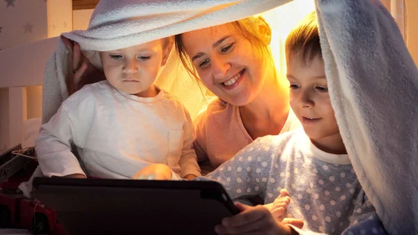 Szczęśliwa Rodzina Siedzi Pod Kocem Nocy Ogląda Kreskówki Tablecie Rodzina — Zdjęcie stockowe