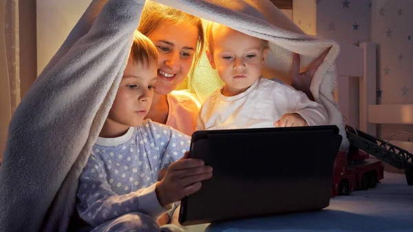 Portrait Smiling Family Pajamas Hiding Tent Bed Watching Video Tablet — Stock Photo, Image