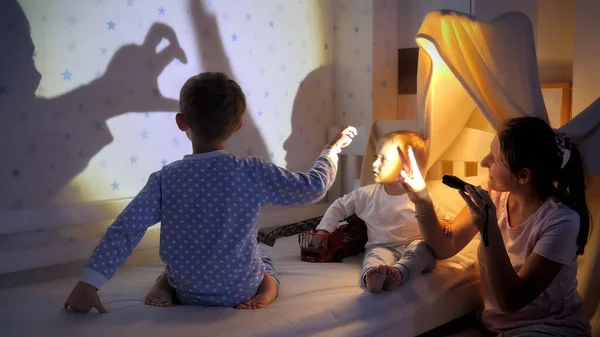 Ung Mor Leker Med Ficklampan Och Hennes Två Söner Visar — Stockfoto