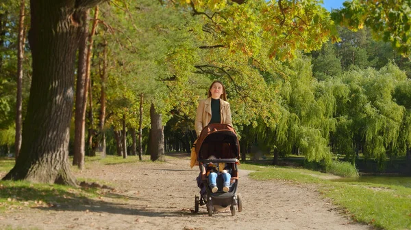 Młoda Matka Spacerująca Swoim Synkiem Śpiącym Wózku Jesiennym Parku Rodzicielstwo — Zdjęcie stockowe