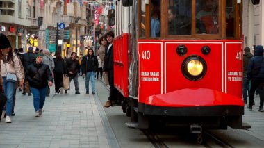 15 Mart 2023, Türkiye, İstanbul. İnsanlar Istiklal caddesinde ünlü kırmızı trene biniyorlar.
