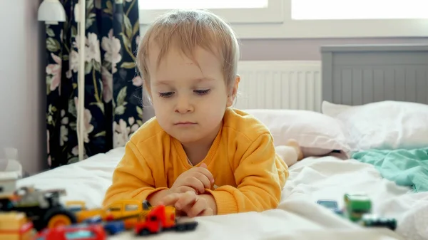 Mały Chłopiec Leżący Łóżku Jeżdżący Zabawkowymi Samochodami Poduszce Rozwój Edukacja — Zdjęcie stockowe