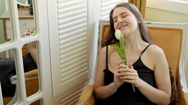 Wanita Cantik Tersenyum Memegang Tulip Putih Santai Kursi Kamar Tidur — Stok Foto