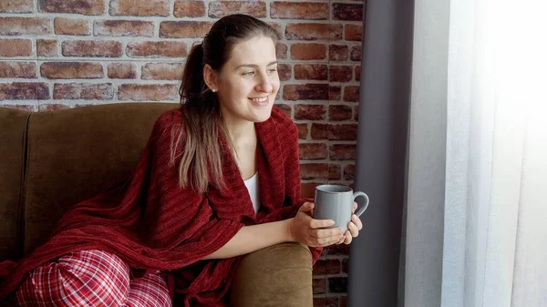 Happy Woman Pajamas Drinking Tea Couch Looking Out Window Female — Stock Photo, Image