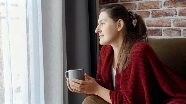 Porträtt Vacker Kvinna Tittar Genom Fönstret Vardagsrummet Medan Dricker Kaffe — Stockfoto
